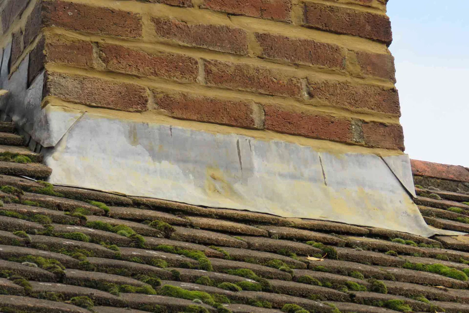 Lead flashing detail around a chimney on a UK tiled roof