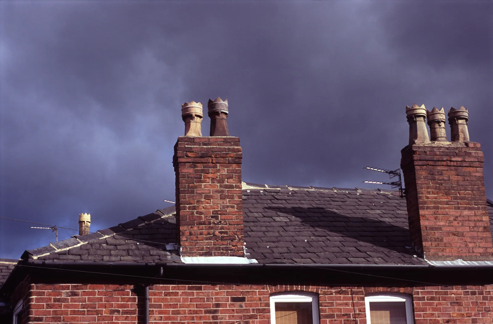Chimney stack on a British terraced house against a stormy sky