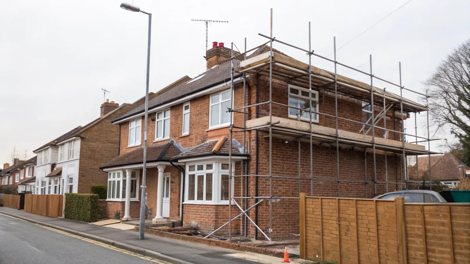 Row of UK terraced houses with scaffolding for roofing work