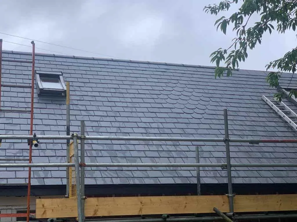 Slate re-roof in progress with scaffolding on a British property