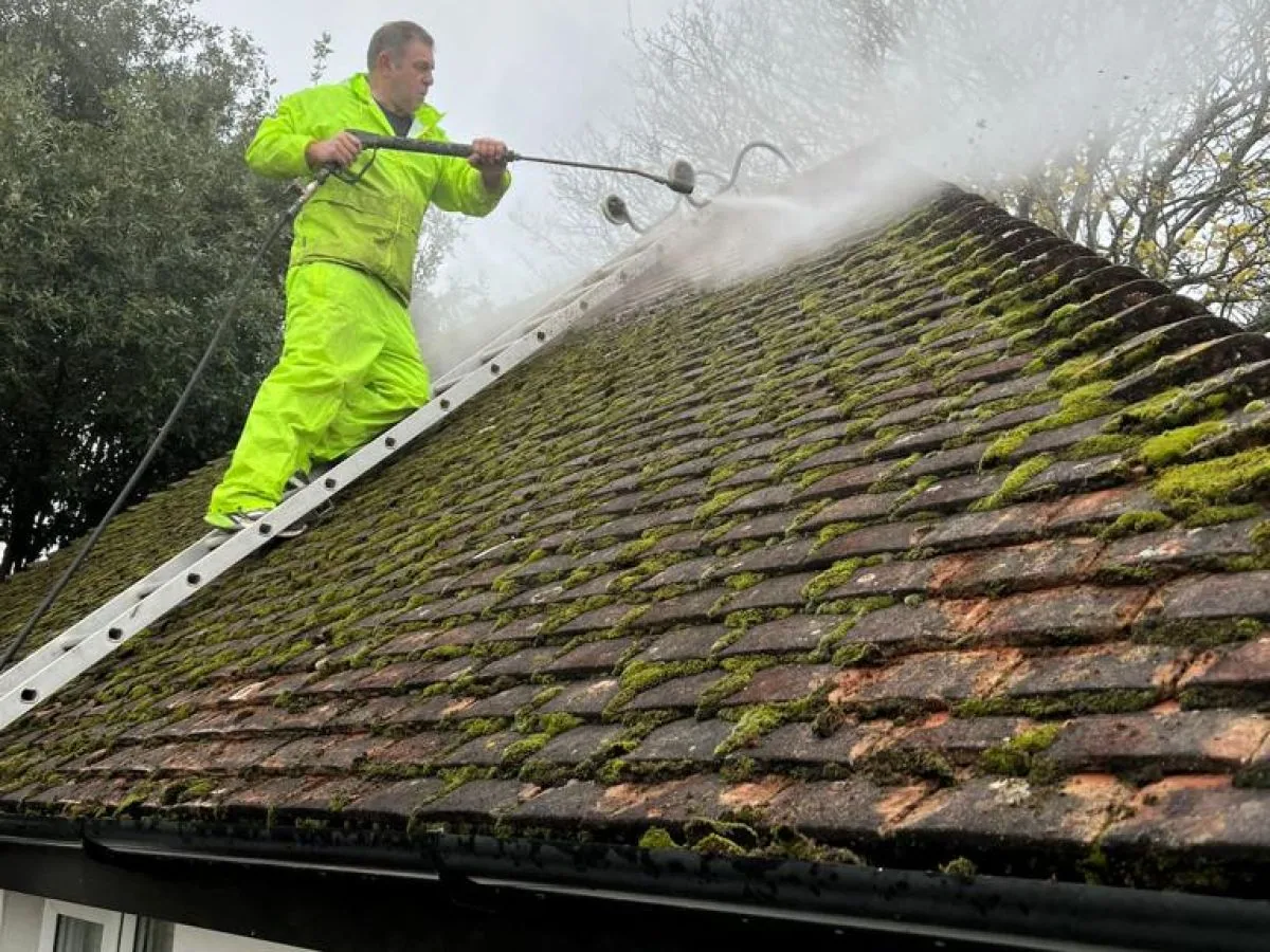 Operative pressure washing moss from a UK roof